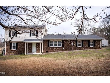 Two-story home with mixed brick and vinyl siding and manicured lawn at 2404 Pearces Rd, Zebulon, NC 27597