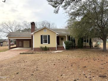 Charming single-story home featuring a brick driveway and covered parking with a well-maintained front yard at 3901 Carson Dr, Sanford, NC 27332