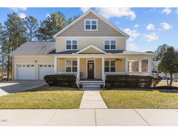 Charming two-story home with a welcoming front porch and well-manicured lawn on a sunny day at 400 Oxford Park Blvd, Oxford, NC 27565