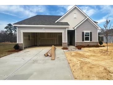 Charming single-Gathering home with a two-car garage, gray siding, and a well-manicured lawn at 46 Rolling Banks Dr, Louisburg, NC 27549