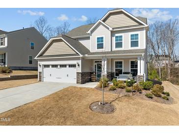 Charming two-story home with a manicured front yard, covered porch, and attached two-car garage at 63 Capewood Ct, Garner, NC 27529