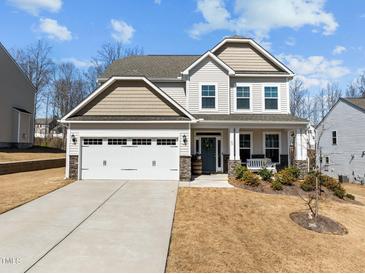 Charming two-story home featuring a covered porch, attached two-car garage, and well-maintained landscaping at 63 Capewood Ct, Garner, NC 27529