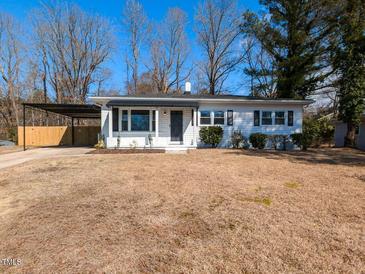 Charming single-story home with white siding, covered parking and neatly kept front yard at 823 Elmira Ave, Durham, NC 27707