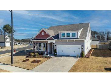 Charming home featuring a two-car garage, gray siding, and a combination of brick and red cedar shake at 1 Parker Pond Ct, Durham, NC 27703