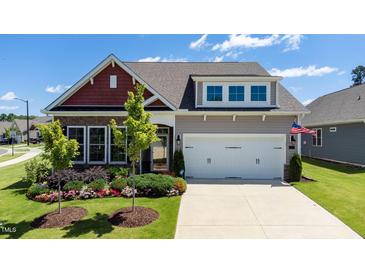 Charming home with a two-car garage and well-manicured lawn and colorful flowerbeds at 1 Parker Pond Ct, Durham, NC 27703