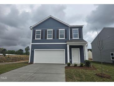 Charming two-story home with a white garage door, white trimmed windows, and a landscaped front yard at 103 Gabriel Ct, Clayton, NC 27520