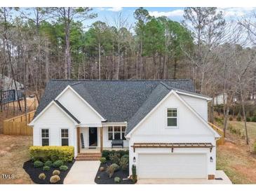 Charming white home with a well-maintained front yard and attached two-car garage, perfect for suburban living at 105 Shawnee Drive, Louisburg, NC 27549