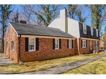 Charming brick home featuring black shutters, a black roof, and a well-maintained landscape at 350 W Lake Trl, Mebane, NC 27302