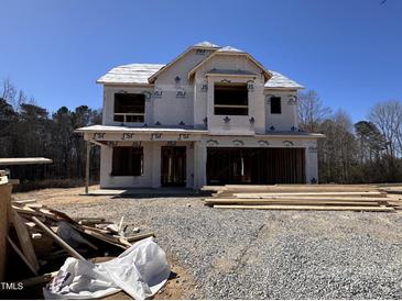 An exterior elevation showcases a house under construction, showing the framing and initial stages of building at 83 W Emily Gardens Dr, Selma, NC 27576