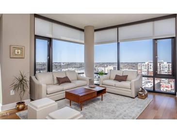 Bright living room showcasing large windows with city views, neutral furnishings, and elegant area rug at 122 N Harrington St # 1105, Raleigh, NC 27603
