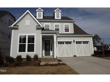 Charming two-story home with a two-car garage, dormer windows, and a well-maintained lawn at 208 Acorn Crossing Rd, Holly Springs, NC 27540
