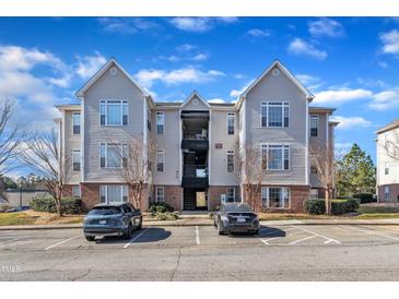 Attractive apartment complex with assigned parking spaces and well-maintained landscaping under a bright, partly cloudy sky at 2520 Friedland Pl # 102, Raleigh, NC 27617