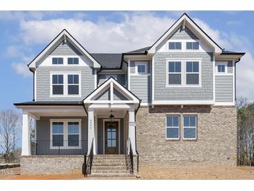 Charming new home with gray siding, brick, and a covered porch, creating a welcoming entrance at 9004 Penny Rd, Raleigh, NC 27606