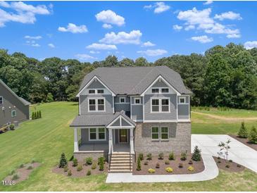 Beautiful two-story home with gray siding, manicured lawn, and inviting front entrance at 9004 Penny Rd, Raleigh, NC 27606