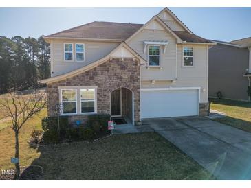 Charming two-story home featuring a stone archway, two-car garage, and nicely landscaped front yard at 138 Daneborg Rd, Durham, NC 27703