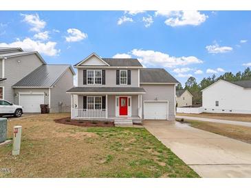 Charming two-story home with a well-manicured lawn, inviting front porch, and attached garage at 197 Scranton Ct, Cameron, NC 28326