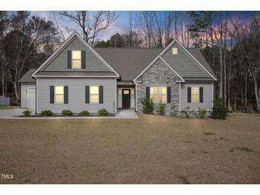 Charming one-story home with stone accents, symmetrical windows, and a well-manicured lawn at 203 Mitchell Manor Dr, Angier, NC 27501