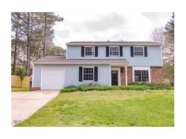 Charming two-story home with light blue siding, black shutters, and a well-maintained front yard at 2513 Boothbay Ct, Raleigh, NC 27613