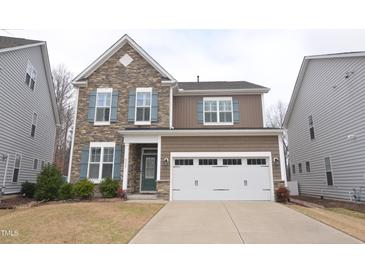 Charming two-story home with a stone accent wall, blue shutters, and a well-maintained front yard at 311 Silverhawk Ln, Durham, NC 27703