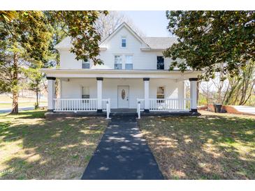 Charming two-story home featuring a covered front porch with white pillars and a well-maintained lawn at 347 W Trade St, Burlington, NC 27217