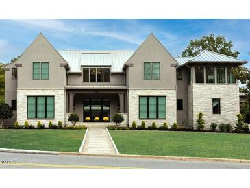 Stunning home with a manicured lawn, stone accents, and a metal roof under a bright blue sky at 4300 Camelot Dr, Raleigh, NC 27609
