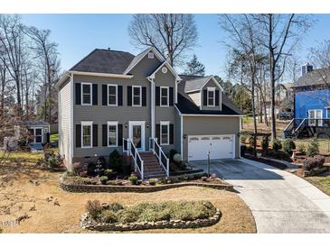 Charming two-story home with a well-manicured front yard, black shutters, and an attached two-car garage at 604 Chadbourne Dr, Durham, NC 27703