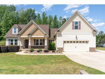Charming home featuring manicured lawn and a two-car garage, blending comfort and curb appeal at 70 Breadnut Dr, Smithfield, NC 27577