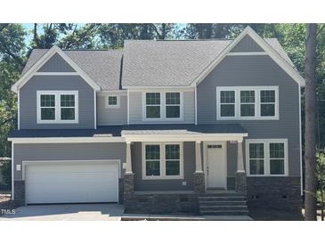Beautiful two-story home with gray siding, stone accents, and an attached two-car garage at 95 Great Smoky Pl, Lillington, NC 27546