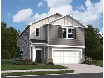 New construction home with two-car garage, welcoming entryway, and neutral-tone horizontal siding at 1144 Solace Way, Rolesville, NC 27571