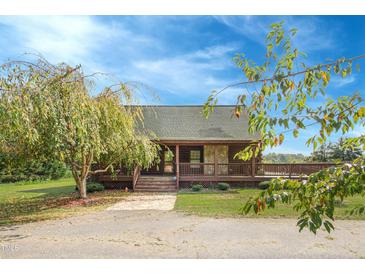 Charming log home featuring a welcoming front porch and beautifully landscaped front yard at 171 Robert Whitfield Rd, Hurdle Mills, NC 27541