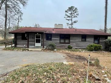 Charming log cabin home with red roof and well-maintained landscaping at 182 Tree Cutters, Sanford, NC 27332
