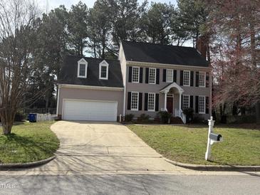 Charming two-story home featuring a two-car garage, dormer windows and a manicured lawn at 1904 Baronsmede Dr, Raleigh, NC 27615