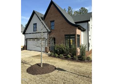 Charming home featuring a blend of brick and siding, black trim, manicured lawn, and a tree in the front yard at 230 Sutherland Dr, Franklinton, NC 27525
