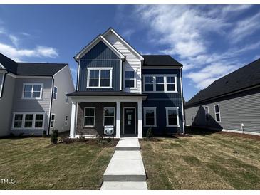 Charming two-story home featuring blue and white siding, a brick accent, and a well-manicured front yard at 269 Marvel Dr # 138, Rolesville, NC 27571