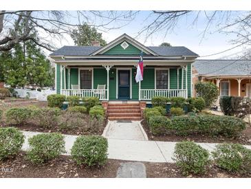 Charming green bungalow featuring a welcoming front porch and manicured landscaping at 603 Polk St, Raleigh, NC 27604