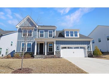 Charming two-story home boasts board and batten siding, stone accents, and an attached two-car garage at 624 Red Arrow Dr, Knightdale, NC 27545