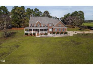 Charming brick home with a large porch and a well-manicured lawn, surrounded by mature trees at 6404 Pulley Town Rd, Wake Forest, NC 27587