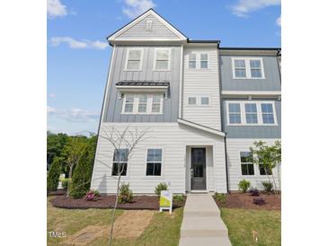 Inviting townhome with a modern, gray and white facade, complemented by well-maintained landscaping at 1035 Zelkova Ln, Chapel Hill, NC 27517