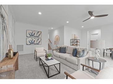 Bright living room featuring neutral tones, modern furniture, and stylish decor creating an inviting atmosphere at 116 Pointe Park Cir, Holly Springs, NC 27540