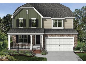 Charming two-story home featuring a stone facade, a covered porch, and an attached two-car garage at 1415 Sparkling Lake Dr # 60, Apex, NC 27523