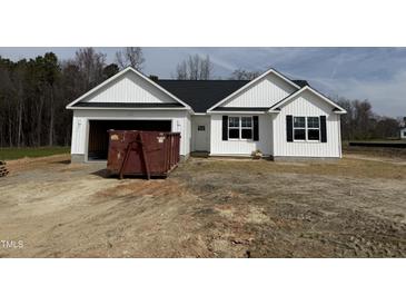 Charming single-story home with a white facade, dark shutters, and an attached garage on a spacious lot at 164 Jones Creek Ln, Lillington, NC 27546