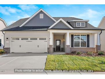 Charming single-Gathering home featuring a two-car garage, welcoming front porch, and attractive landscaping at 1811 Parham Dr, Graham, NC 27253