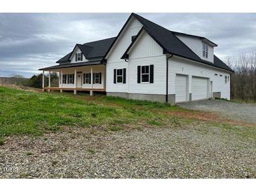 Charming white farmhouse with a covered porch and a two-car garage at 187 Dairymont Dr, Pittsboro, NC 27312