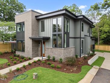 Modern home featuring a gray exterior with a brick accent, professionally landscaped lawn, and a welcoming front entrance at 2305 Turners Aly, Raleigh, NC 27607