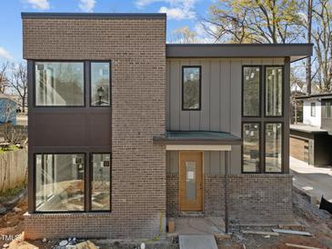 Modern two-story home with brick and gray wood facade featuring large windows and a contemporary design at 2305 Turners Aly, Raleigh, NC 27607
