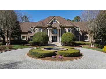 Stunning brick home featuring a circular driveway, well-manicured landscaping, and classic architectural details at 2421 Acanthus Dr, Wake Forest, NC 27587