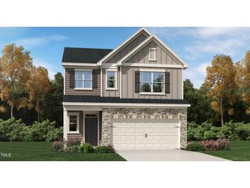 Charming two-story home with stone accents, a two-car garage, and a beautifully landscaped front yard at 764 Swim Cave Ln, Wendell, NC 27591