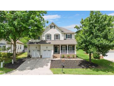 Charming two-story home with green shutters, front porch, two-car garage, and well-manicured landscaping at 1106 Bellenden Dr, Durham, NC 27713