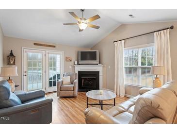 Cozy living room with fireplace, vaulted ceiling, and comfortable seating arrangement at 201 Moss Creek Dr, Clayton, NC 27520