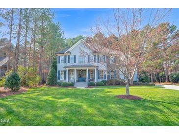 Charming two-story home with manicured lawn, mature trees, and a welcoming front porch at 204 Dartmoor Ln, Raleigh, NC 27614